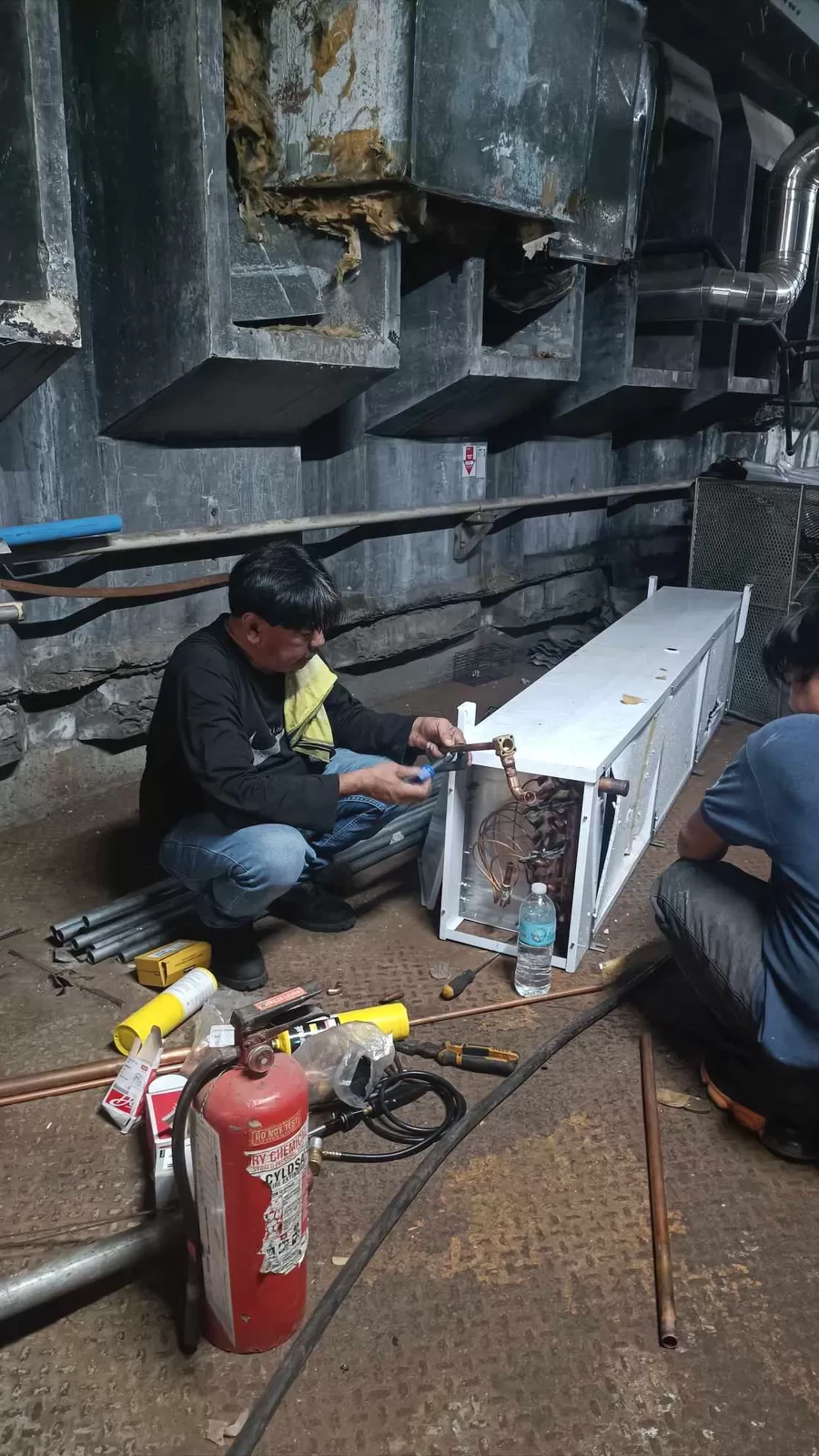 Field service technician repairing refrigeration equipment